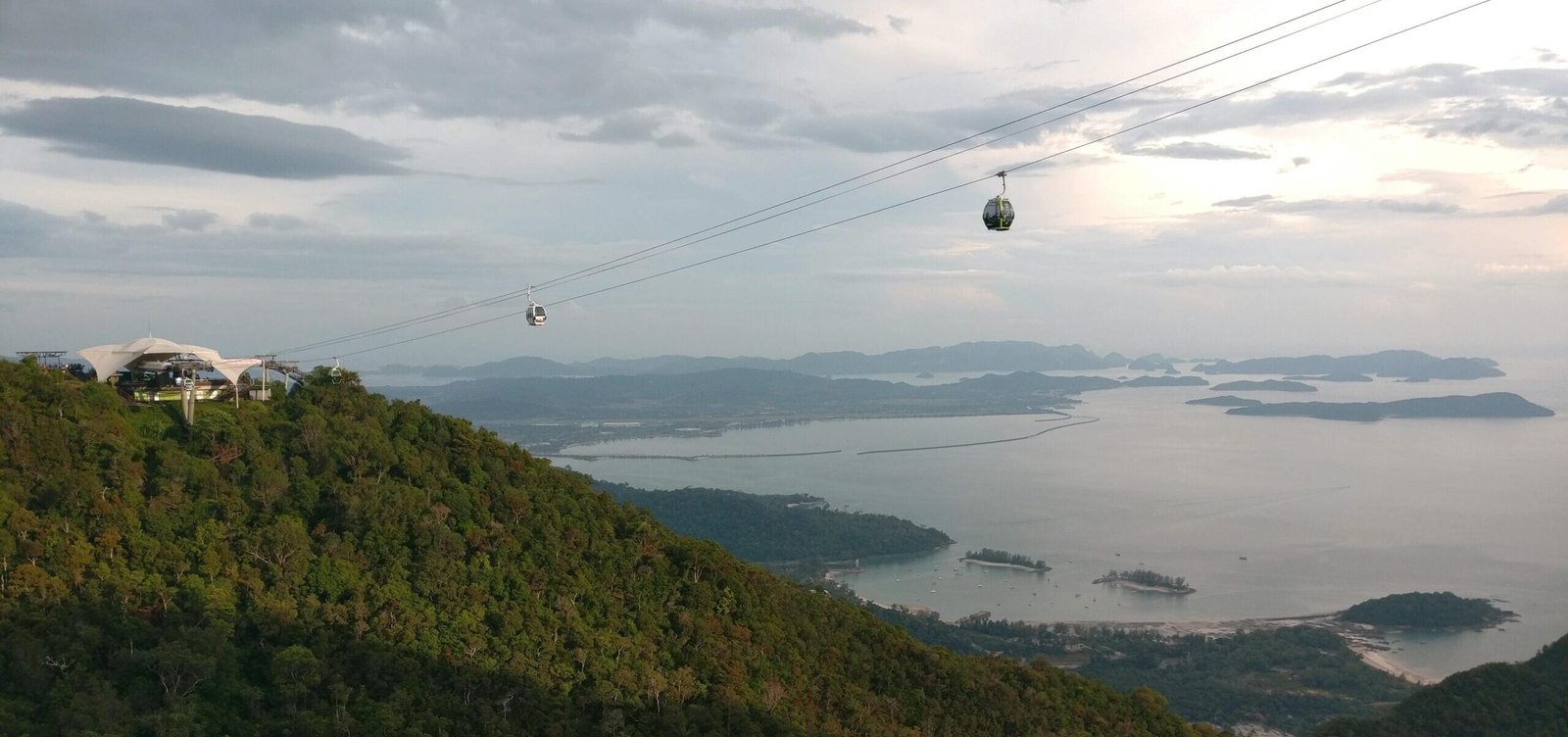 Breathtaking aerial view of Langkawi's cable car with lush forests and serene coastline.
