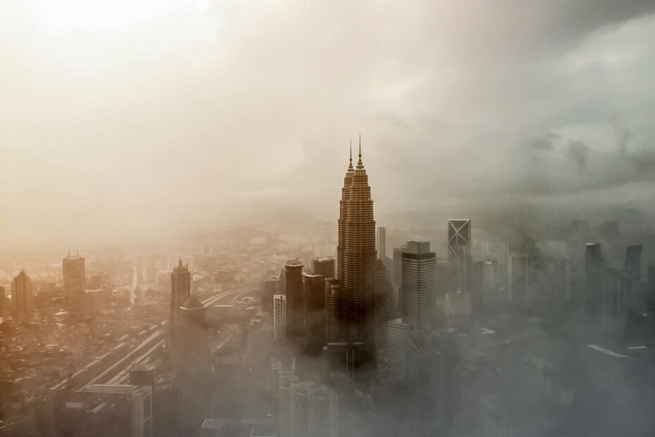 Kuala Lumpur skyline beneath clouds and haze