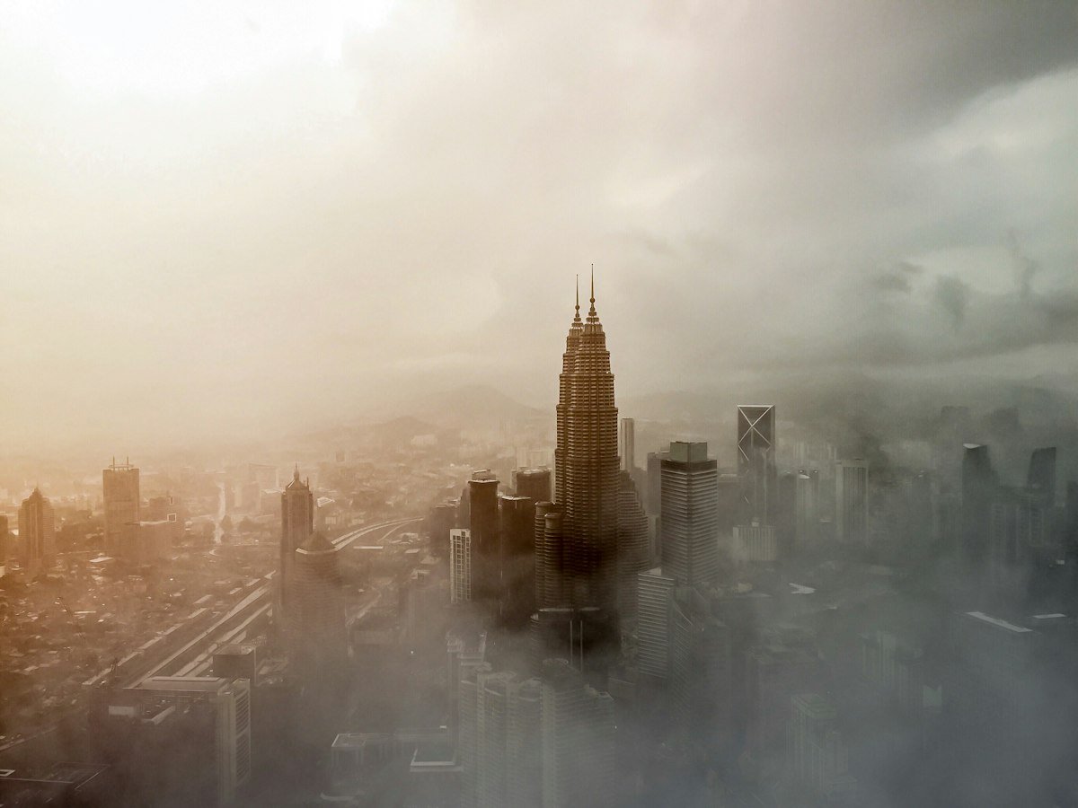 Kuala Lumpur skyline beneath clouds and haze